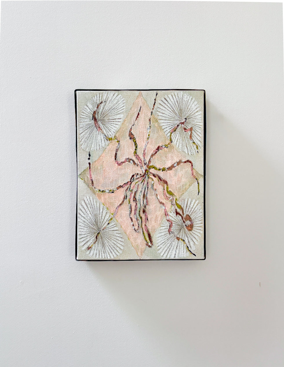 Framed abstract artwork with pink and green design on a white wall