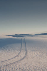 Vast desert landscape with tire tracks.